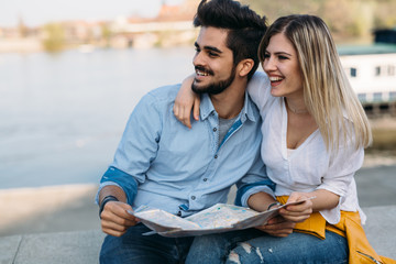 Fototapeta premium Happy tourist couple with map traveling outdoors