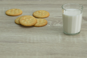 MILK GLASS AND CRACKERS
A glass of milk with pile of crackers on the wood top table. 