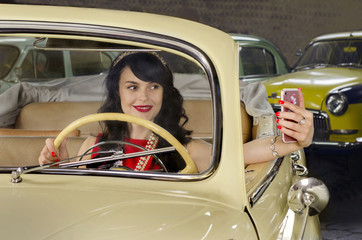 Naklejka premium young woman doing a photo of yourself in a retro car