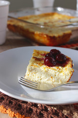 Cottage cheese casserole with oatmeal and lemon zest, served with a cherry.