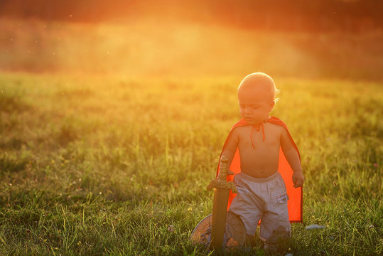 Little boy king outdoors at sunset with ray of light