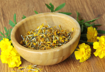 Calendula herb, yellow flower or herb dried in a wooden bowl for tea