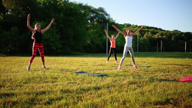 group of young people having kick boxing training , outdoor