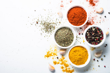 Various spices in a bowls on white.