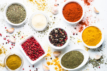 Various spices in a bowls on white stone table. Top view