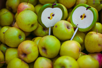 Candies in form of apples lie on apples