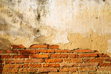 Ancient thai temple cracked brick wall under evening warm sunlight
