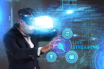 Business, Technology, Internet and network concept. Young businessman working in virtual reality glasses sees the inscription: Live streaming