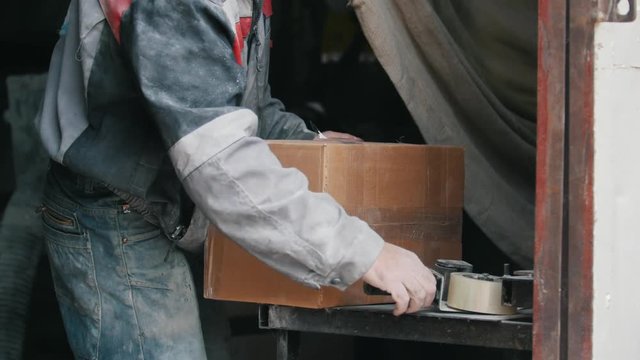 Warehouse workers packing up box in a industrial warehouse