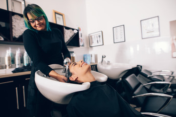Hairdresser washing hair of customer at salon © Jacob Lund