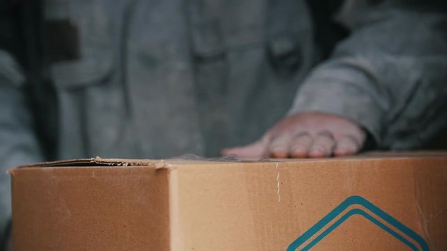 Warehouse workers packing up box with sticky tape in a industrial warehouse