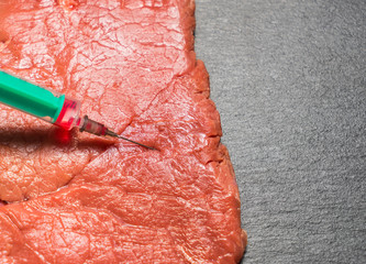 Food scientist injecting raw mea