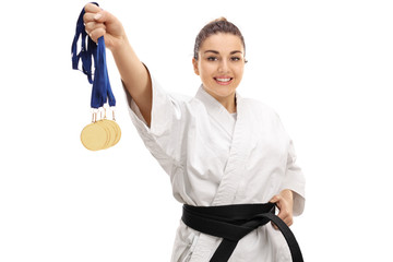 Karate girl showing gold medals and smiling