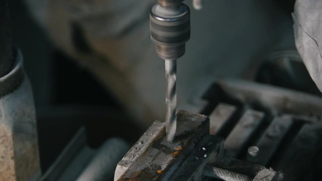 Metal processing - drill is drilling the iron item in workshop