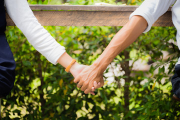Naklejka na ściany i meble Couple holding hands in the park, together