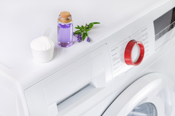 natural washing powder with essential oil and lavender flowers over washing machine