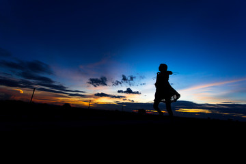 Silhouette of woman posing at sunset or sunrise