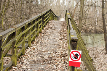 Old wooden broken bridge closed and with no entry sign