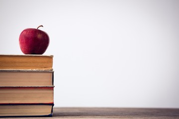 Apple on stack of book at table