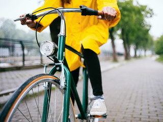 Obraz premium Close up of woman wearing raincoat while riding bicycle