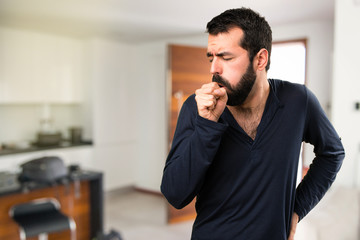 Handsome man with beard coughing a lot inside house