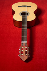 Fototapeta na wymiar acoustic guitar on red velvet fabric, closeup object