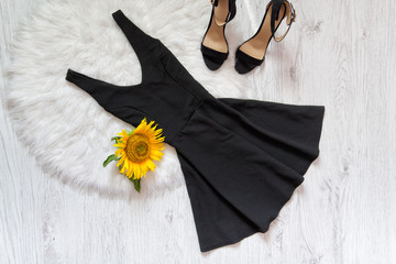 Black short and shoes on white fur sunflowers. Fashionable concept