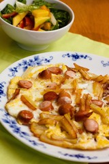 Sausage frittata with french fries and salad