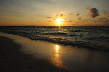 Fototapeta na wymiar Beautiful Golden Sunset or Sunrise over the rippling Ocean