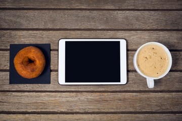 Overhead view of digital tablet with coffee cup donut