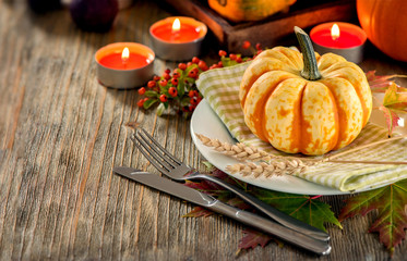 Obraz na płótnie Canvas Autumn table setting with pumpkings and candles, fall home decoration for festive dinner