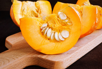 Cut pumpkin on a wooden board. Selective focus.