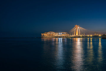 A restaurant on the water in the center of the city, a bridge illuminated by lanterns in the Adriatic Sea.