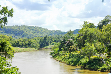 Stock Photo - By the river side. View of a holiday resort gardens