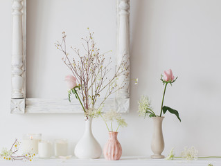 flowers in a vase and candles on white background