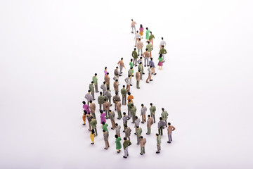 Line of miniature people view from above, over white background.