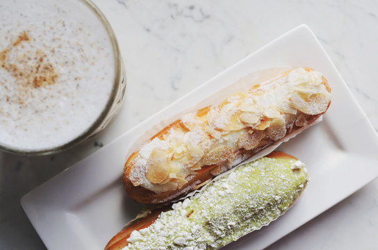 Almond and pistachio eclairs and latte, top view