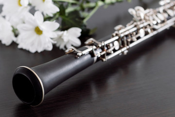 Musical background, poster - oboe on black background with flowers .