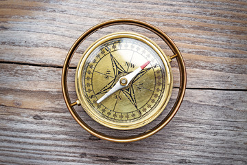 vintage brass compass isolated on wooden table