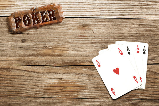 poker sign and four aces on wooden background