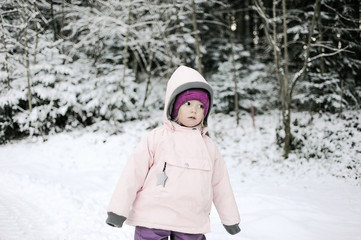 Fototapeta na wymiar Cute three years old girl walking in the snow