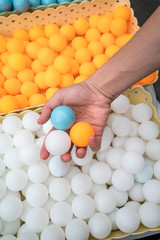 Hand holiding ping-pong balls.