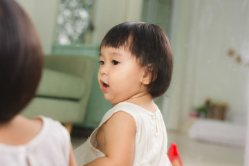 Little cute asian baby girl sitting on floors playing