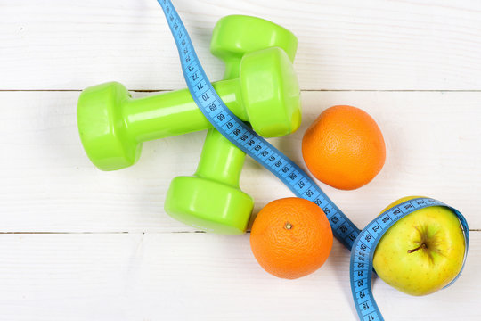 ideal size concept, dumbbells weight with measuring tape, fruit