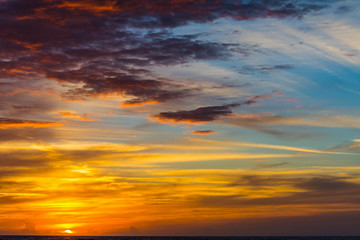 Naklejka na ściany i meble Cloudy sky over the sea at sunset