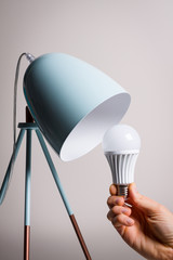 Changing the bulb for led bulb in table lamp in turquoise colours.