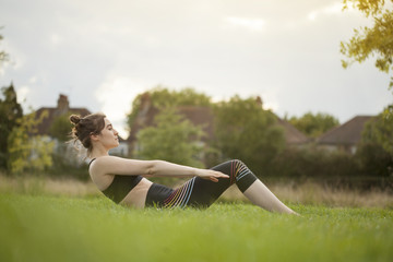 Young woman doing yoga and stretching in park