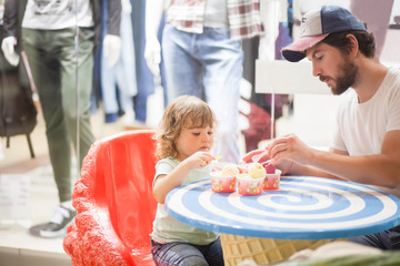 Father and daughter eating ice cream at the restaurant