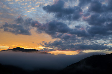 Obraz premium mountain range tropical rainforest canopy at southern of Thailand with more cloud sunset time, copy space for text layout.