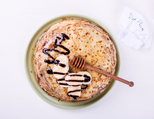 Stack of Thin pancakes with Honey,Banana,Chocolate.  on a White Background.Tradition,Holiday,Dessert,Breakfast,Pastries.Copy space for Text. selective focus.